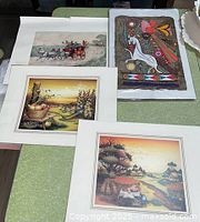 Four matted prints laid out on table