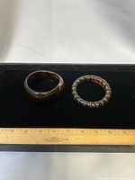 Top view of both bracelets on black display with ruler