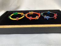 Three rubber bracelets displayed on velvet tray