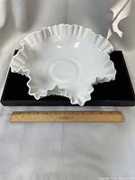 Top view showing full ruffled rim and smooth interior of the milk glass bowl