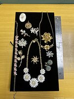 All jewellery pieces arranged on black velvet board showing group and scale