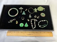 Full tray view showing all jade jewellery pieces including bangle, pendants, rings, earrings, brooch and bracelets
