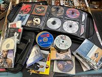 Binder open showing multiple discs, loose jewel cases and spindle discs