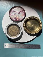 Front view of all three small plates with ruler for scale