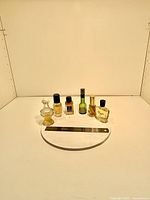 Front view of six small perfume bottles with ruler for scale