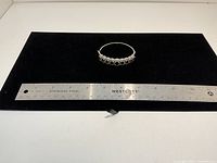 Bracelet fully closed beside ruler showing overall length