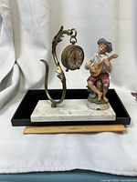 Front view showing brass clock, figurine, marble base