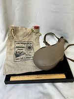 Canvas Pioneer water bag and leather bota canteen overview with ruler for scale