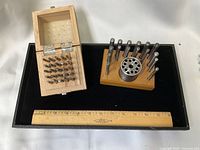 Overall lot view with wooden case, punch holder, anvil, ruler