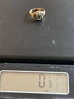 Ring on digital scale reading 0 1⁄8 oz