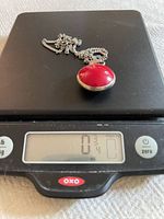 Red side of sterling pendant on digital scale