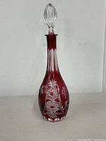 Full view of cranberry cut to clear decanter with stopper