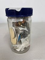 Jar front view showing assorted earrings inside