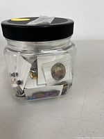 Jar of assorted earrings side view showing contents