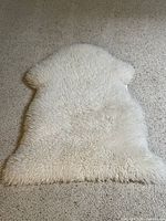 Top view of white sheepskin rug on carpet