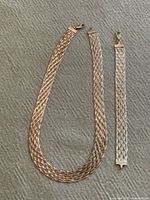 Necklace and bracelet laid flat showing weave and clasps