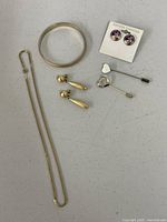 Full lot showing bracelet, necklace, earrings pairs, heart pins, unicorn stud earrings on card