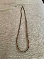 Full view of herringbone necklace laid flat showing overall length