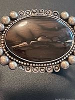 Front view of cuff showing petrified wood stone and beaded border