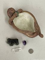 Top view of otter bowl with crystals and quarter for scale