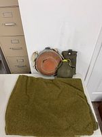 Blanket folded with three canteens displayed