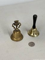 Both bells side by side with quarter for scale