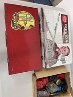 Red metal Erector No. 6 1/2 case, Rocket Launcher boxed set, and spare parts box overview