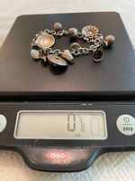 Bracelet on scale showing full view of links and charms