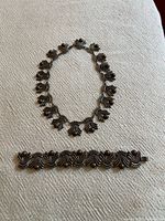 Full view of necklace and bracelet laid flat to show design and scale