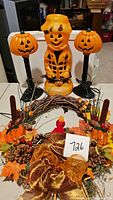 Overall view of scarecrow blow mold, two pumpkin lanterns, and decorated fall wreath.