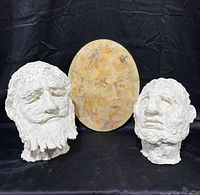 Front view of both clay heads and oval painting