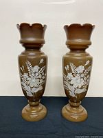Front view of both brown Bristol clam-broth glass vases showing painted white floral designs
