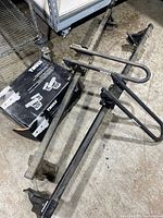 Boxed Thule Top Deck 881 and two Thule kayak carrier assemblies on floor
