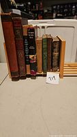 Group of eight books on wooden stand