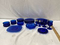 Full grouping of cobalt blue glass pieces displayed on table