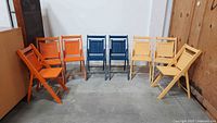 All eight painted wooden folding chairs arranged in semicircle