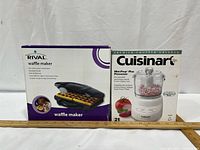 Front view of both boxed appliances with ruler for scale