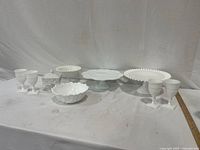 Seven milk glass serveware pieces arranged on table