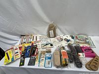 Wide overview showing full assortment of packaged notions, kits, fabric and tools