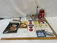 Group shot of entire lot with cookbooks, jar, utensils, labels, grinder