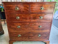 Front view showing five drawers and brass pulls