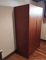 Closed wardrobe showing exterior teak-tone veneer and form