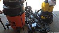Shop-Vac vacuum and Kärcher pressure washer with hoses and cords visible