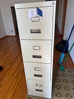 front view of beige four-drawer metal filing cabinet