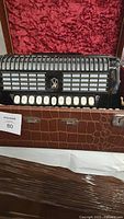 Accordion front view inside case showing grille, register switches, keys, and case exterior