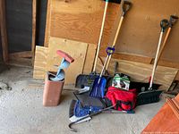 Group shot of auger, shovels, bags, broom