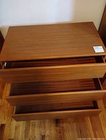 Front view of dresser with all three drawers partially open showing interior condition