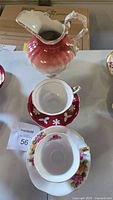 Overall view showing Shafford red floral teacup set, Royal Albert floral teacup set, ceramic pitcher
