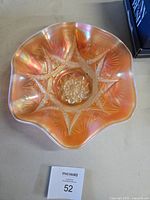 Top view of peach opalescent carnival glass bowl showing ruffled rim and starburst pattern