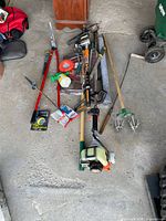 Overall view of pile of yard tools including STIHL trimmer and hand tools